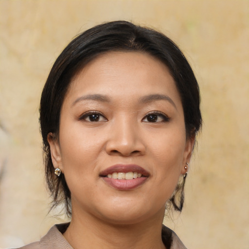 Joyful asian young-adult female with medium  brown hair and brown eyes