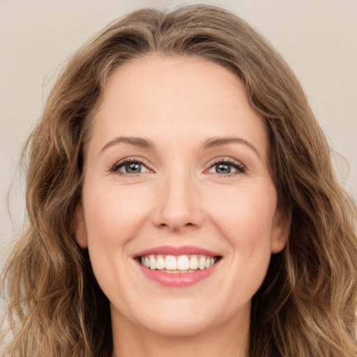 Joyful white young-adult female with long  brown hair and green eyes