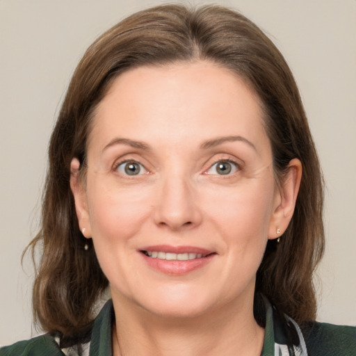 Joyful white adult female with medium  brown hair and grey eyes