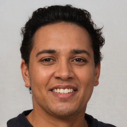 Joyful latino young-adult male with short  brown hair and brown eyes