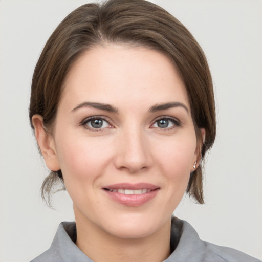 Joyful white young-adult female with medium  brown hair and grey eyes