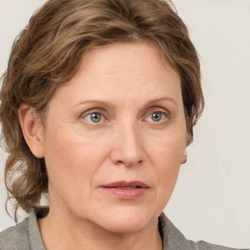 Joyful white adult female with medium  brown hair and grey eyes