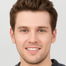 Joyful white young-adult male with short  brown hair and grey eyes