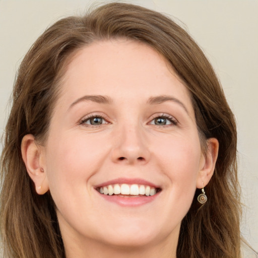 Joyful white young-adult female with long  brown hair and grey eyes