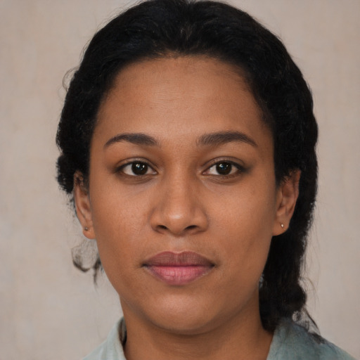 Joyful black young-adult female with short  black hair and brown eyes