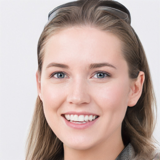 Joyful white young-adult female with long  brown hair and blue eyes