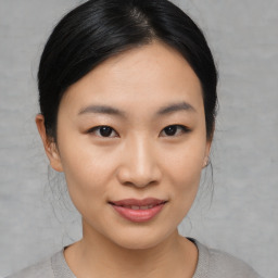 Joyful asian young-adult female with medium  black hair and brown eyes