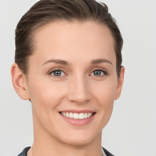 Joyful white young-adult female with short  brown hair and grey eyes