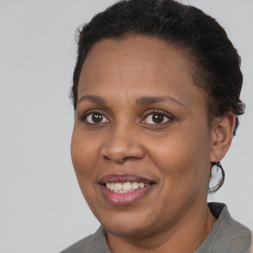 Joyful black adult female with short  brown hair and brown eyes
