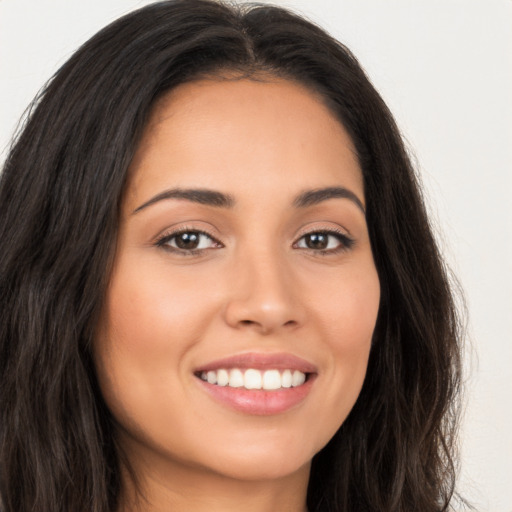 Joyful latino young-adult female with long  brown hair and brown eyes