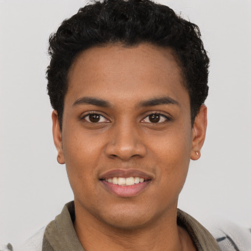 Joyful black young-adult male with short  brown hair and brown eyes