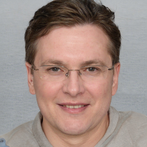 Joyful white adult male with short  brown hair and blue eyes