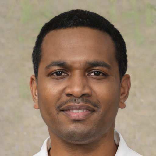 Joyful black young-adult male with short  black hair and brown eyes