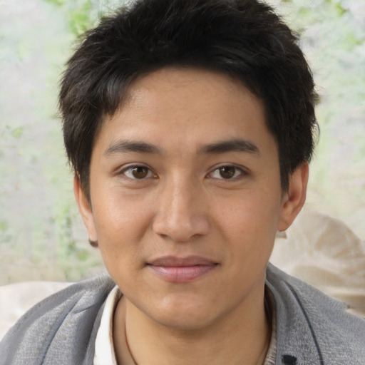 Joyful asian young-adult male with short  black hair and brown eyes
