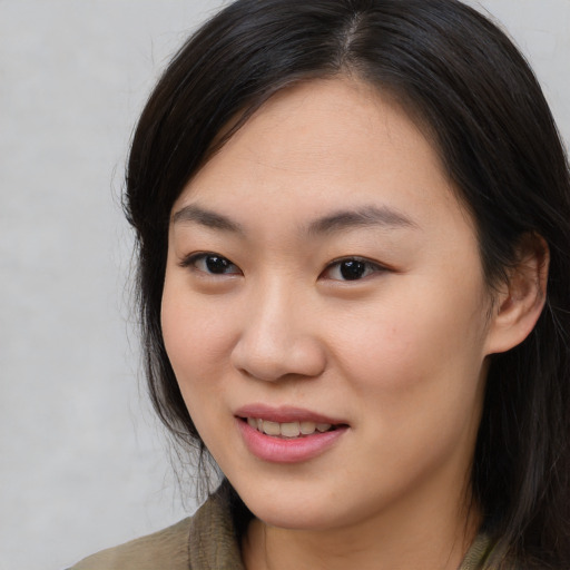Joyful asian young-adult female with long  brown hair and brown eyes