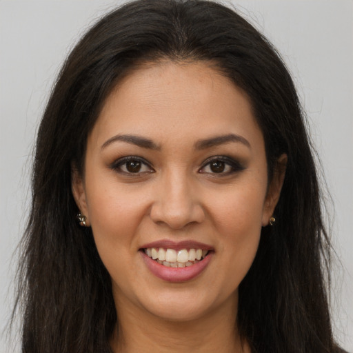Joyful latino young-adult female with long  brown hair and brown eyes