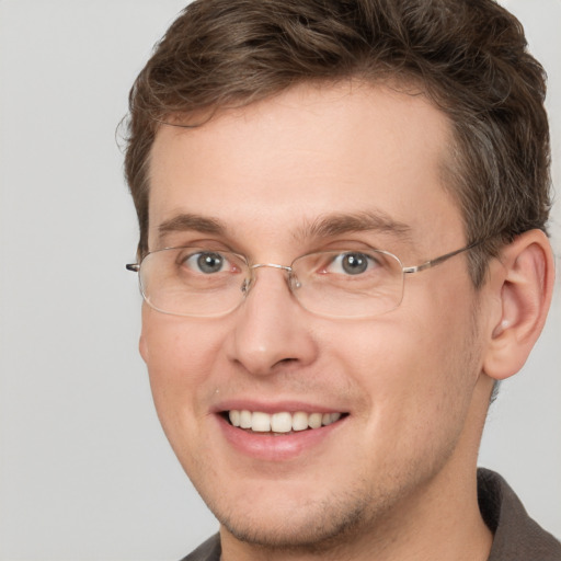 Joyful white adult male with short  brown hair and grey eyes