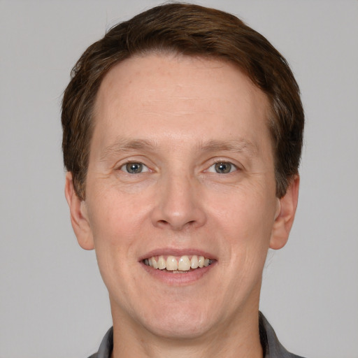 Joyful white adult male with short  brown hair and grey eyes