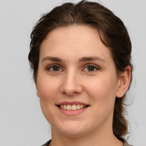 Joyful white young-adult female with medium  brown hair and green eyes