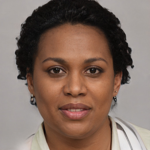 Joyful black adult female with short  brown hair and brown eyes