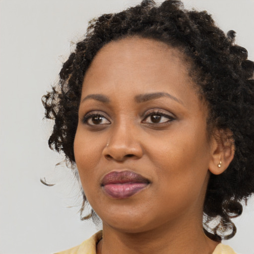 Joyful black young-adult female with medium  black hair and brown eyes