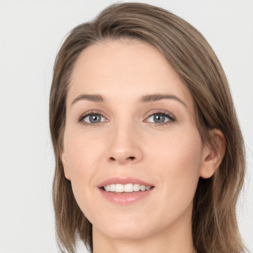 Joyful white young-adult female with long  brown hair and grey eyes