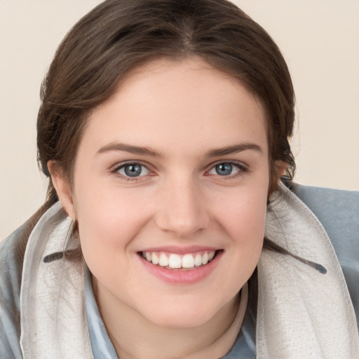 Joyful white young-adult female with medium  brown hair and blue eyes