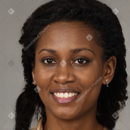 Joyful black young-adult female with long  black hair and brown eyes