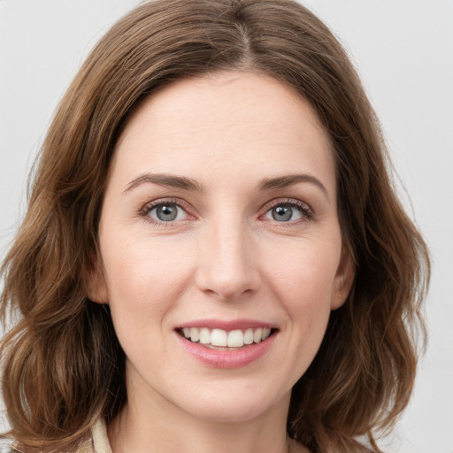 Joyful white young-adult female with medium  brown hair and green eyes