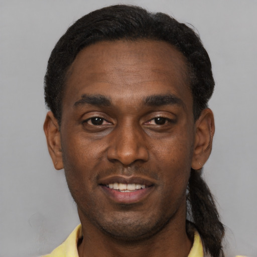 Joyful black adult male with short  brown hair and brown eyes