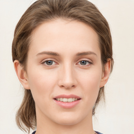 Joyful white young-adult female with medium  brown hair and grey eyes