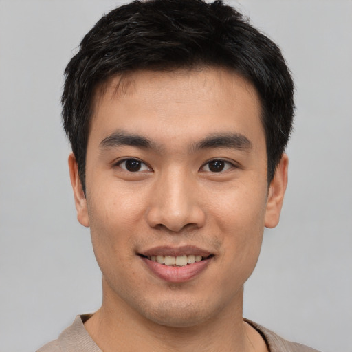 Joyful asian young-adult male with short  brown hair and brown eyes