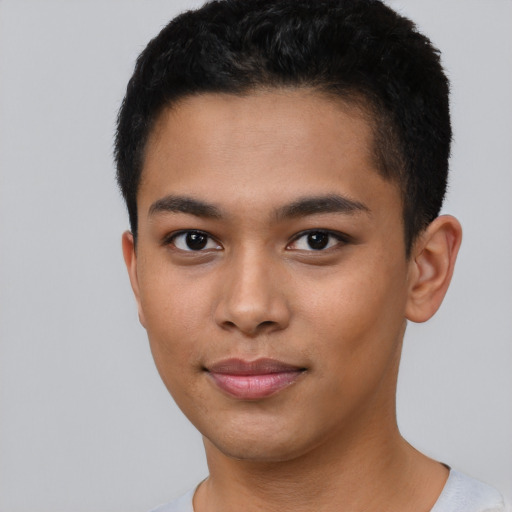 Joyful latino young-adult male with short  black hair and brown eyes