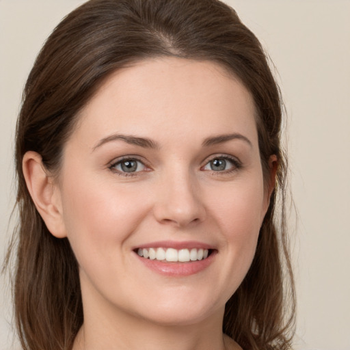 Joyful white young-adult female with long  brown hair and grey eyes