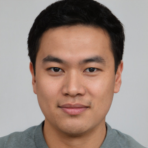 Joyful asian young-adult male with short  brown hair and brown eyes