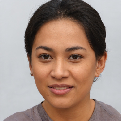 Joyful latino young-adult female with short  brown hair and brown eyes