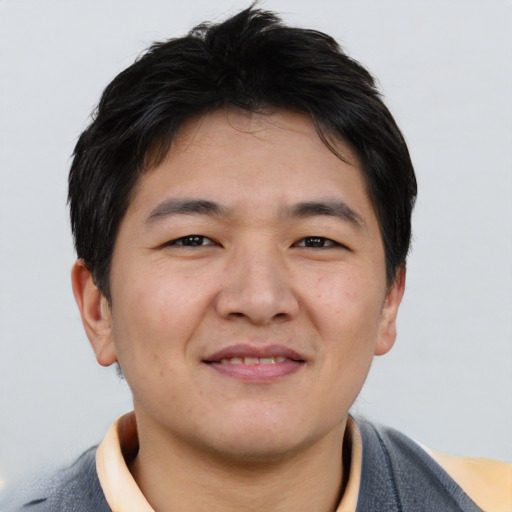 Joyful asian young-adult male with short  brown hair and brown eyes