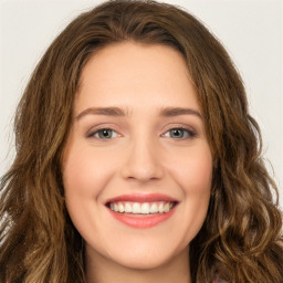 Joyful white young-adult female with long  brown hair and green eyes