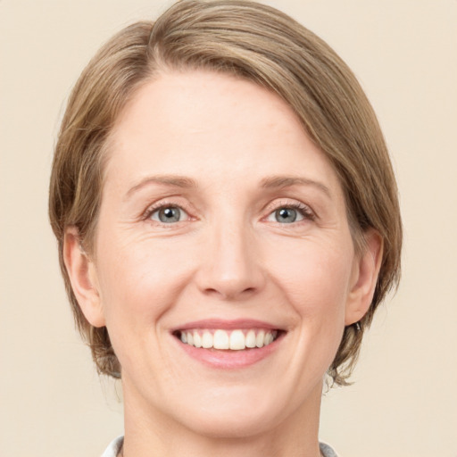 Joyful white adult female with medium  brown hair and green eyes