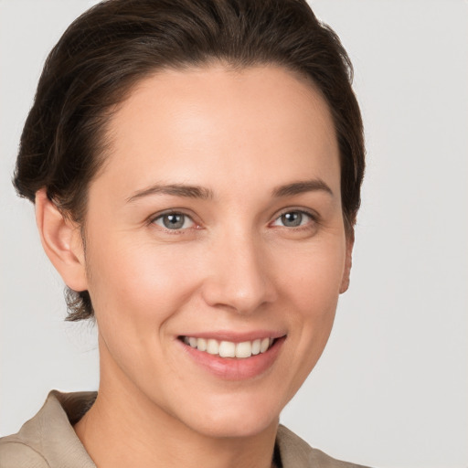 Joyful white young-adult female with short  brown hair and grey eyes