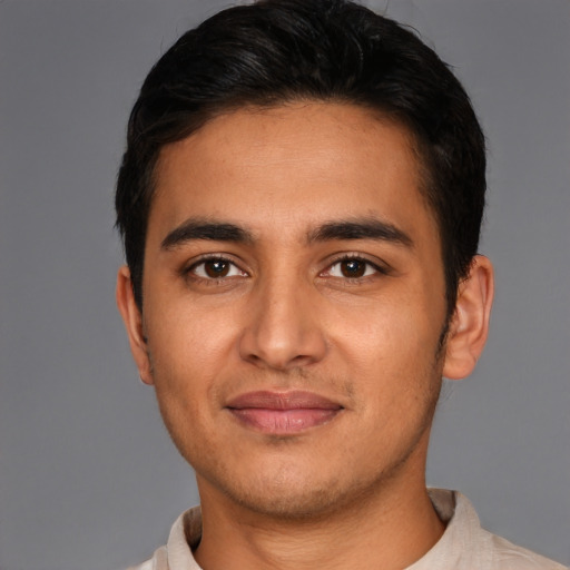 Joyful latino young-adult male with short  brown hair and brown eyes
