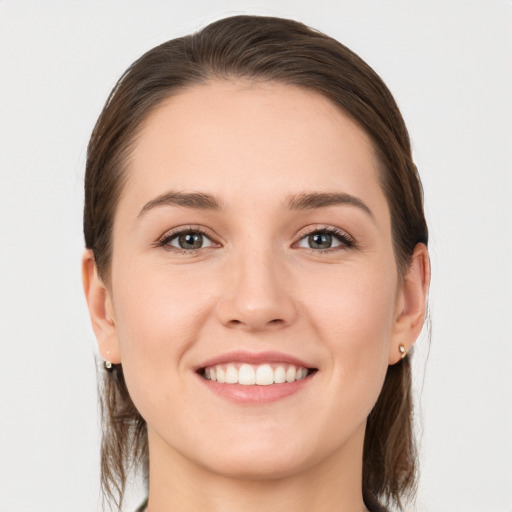 Joyful white young-adult female with medium  brown hair and grey eyes