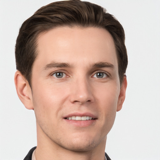 Joyful white young-adult male with short  brown hair and grey eyes