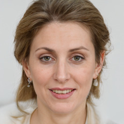 Joyful white adult female with medium  brown hair and green eyes