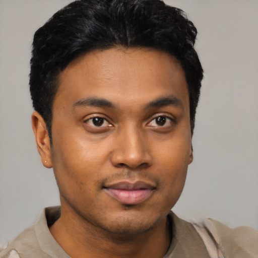 Joyful latino young-adult male with short  black hair and brown eyes