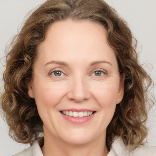 Joyful white adult female with medium  brown hair and green eyes