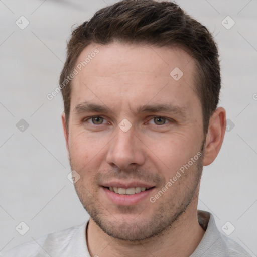 Joyful white young-adult male with short  brown hair and grey eyes