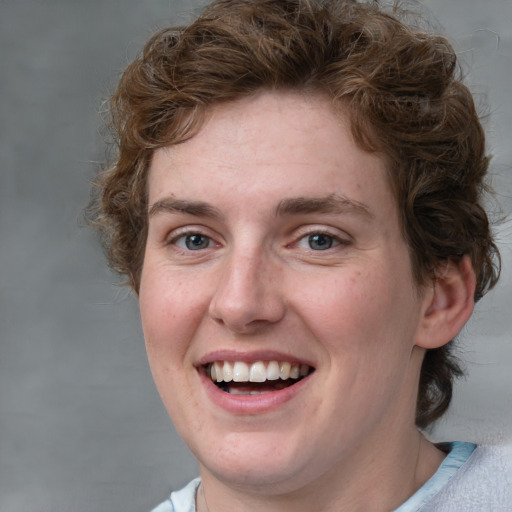 Joyful white young-adult female with short  brown hair and blue eyes