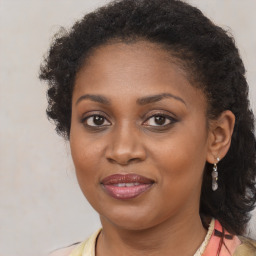 Joyful black young-adult female with long  brown hair and brown eyes