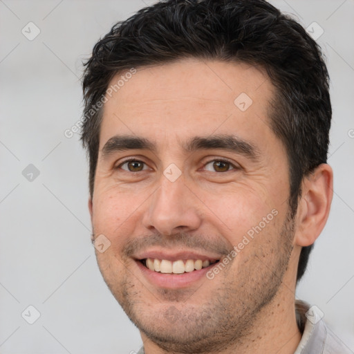 Joyful white adult male with short  brown hair and brown eyes